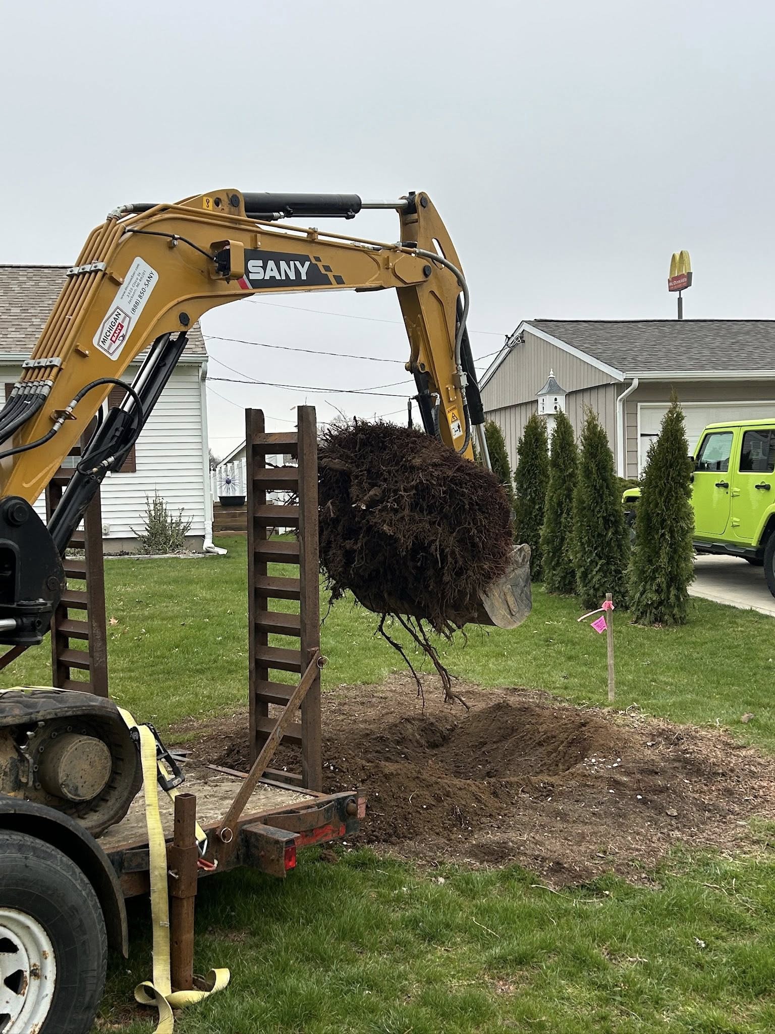 Professional excavator performing stump removal services in Grass Lake, Michigan